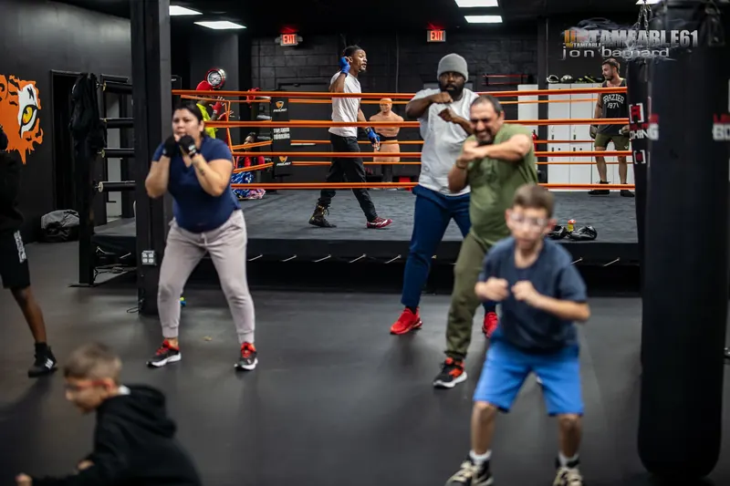 Adults and kids shadowboxing together in a group class