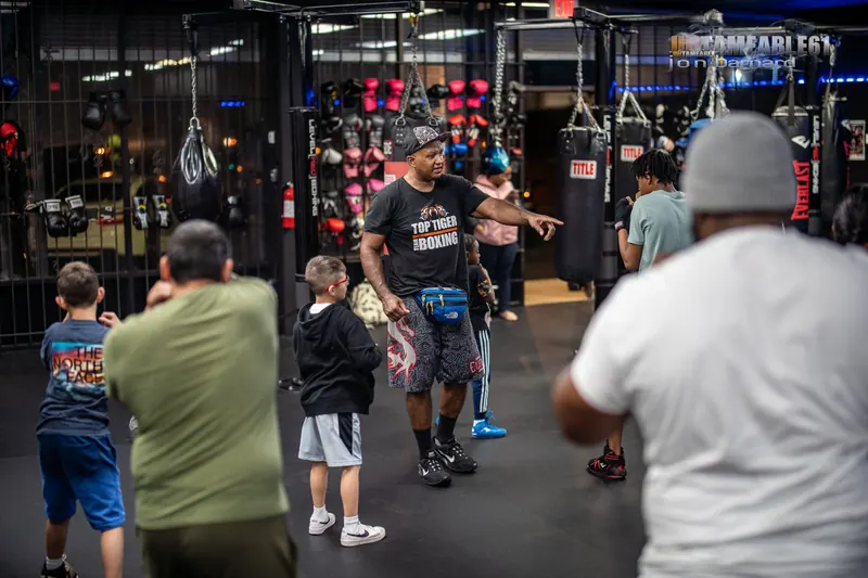 Coach directing a kids class in front of the glove wall