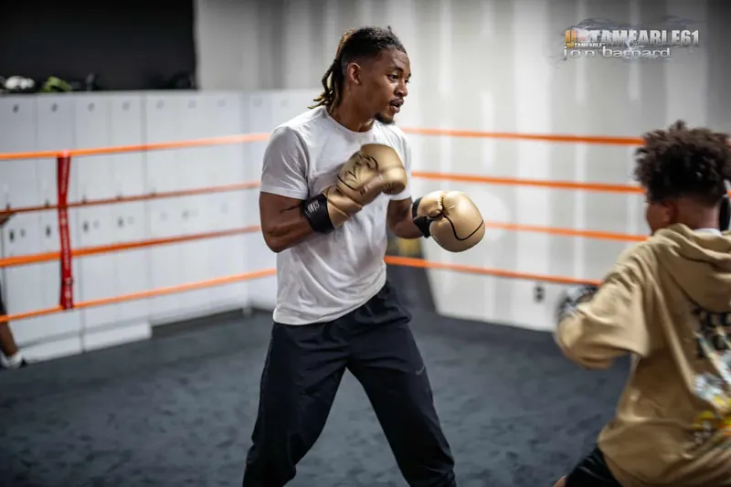 Coach in gold gloves demonstrating a punch