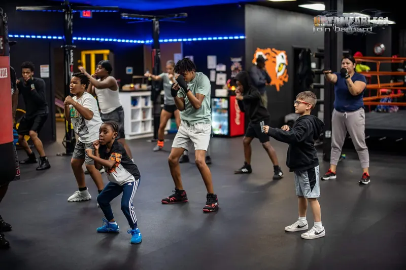 Full group class in stance under the tiger mural
