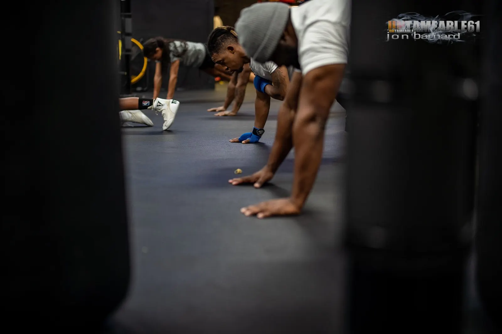 Boxers doing push-ups between heavy bags