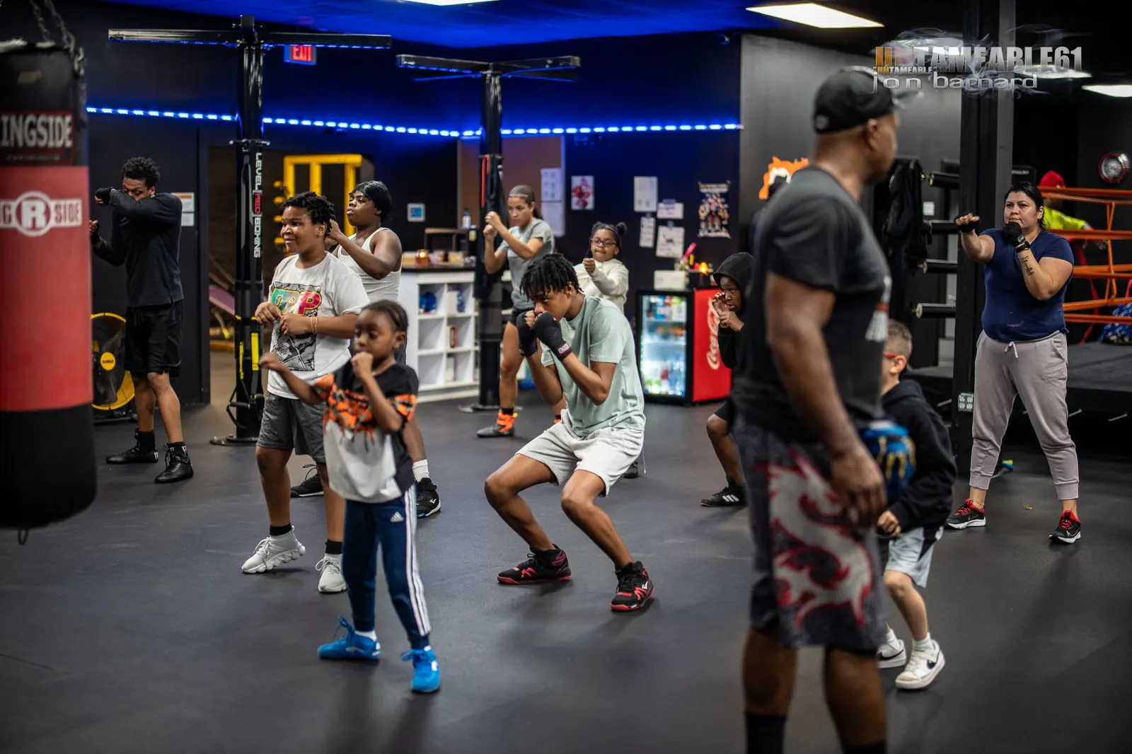 A group class shadowboxing under blue lights